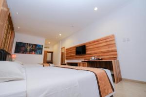 日惹日惹帕里斯皇家酒店的配有一张床和一台平面电视的酒店客房