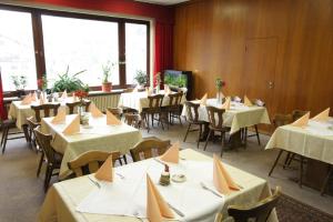 Finkenbach加斯特霍夫促特劳伯酒店的用餐室配有桌椅和白色桌布