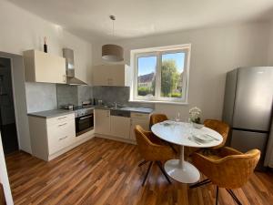 施泰尔Design-Appartement Steyr的厨房配有白色的桌椅和窗户。
