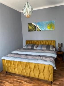 施泰尔Design-Appartement Steyr的卧室内的一张床位,卧室内有黄色床头板