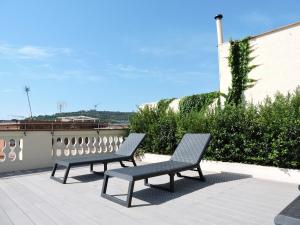 巴塞罗那Hotel Raval House的两个长椅坐在屋顶上