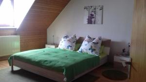 特里滕海姆Ferienwohnung Bergblick的一间卧室配有一张带绿床单和枕头的床。