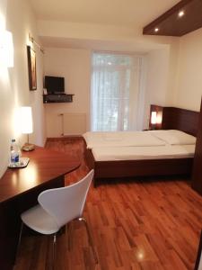 塞尼察Hotel Arli的一间卧室配有一张大床和一张桌子及椅子