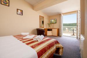 内乌姆卢纳酒店的酒店客房设有一张床和一个阳台。