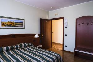 特雷维索阿格里图里斯莫卡西纳里酒店的一间卧室配有带条纹毯子的床