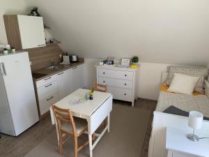 埃伦豪森Steira-Studios的小厨房配有白色的桌子和沙发