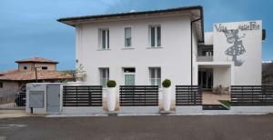塞斯托拉Hotel Villa delle Fate, BW Signature Collection的前面有黑色围栏的白色房子