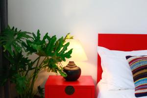 北京北平国际青年旅舍的卧室配有红色床头柜、台灯和植物