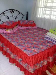 Kampong TelokAMIMAS HOMESTAY的床上有红色和蓝色的被子