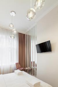 利沃夫Avangard DeLuxe Art Apart的一间酒店客房,配有一张床和一台墙上的电视