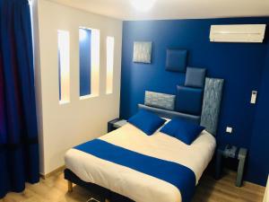 蒂耶尔Pavillon Fani的一间卧室拥有蓝色的墙壁,配有一张带蓝色枕头的床。