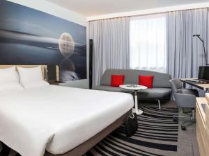 约克诺富特约克酒店的酒店客房设有一张大床和一张沙发。