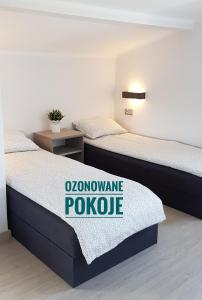 乌斯特卡Dom Wypoczynkowy Oliwka的两张床铺,房间上标有标志
