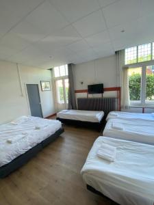 宰斯特CoronaZeist-Utrecht NL的一间设有四张床的窗户客房