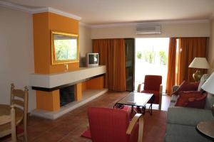 珀彻斯Apartamento T1 - Praia Senhora da Rocha的客厅设有壁炉、沙发和桌子