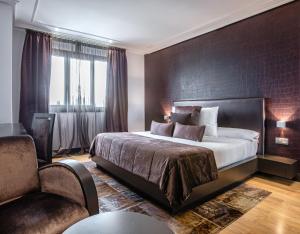 卡尔瓦略Hotel Pensua Punta del Este的一间卧室配有一张大床和一把椅子