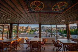 格雷梅Termessos Hotel的用餐室设有桌椅和窗户。