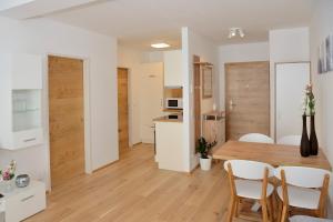 MühlbachlApartment Serles的厨房以及带木桌和椅子的用餐室。