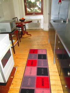 柏林静谧度假屋 - 柏林米特区的厨房铺有红色和黑色地毯。