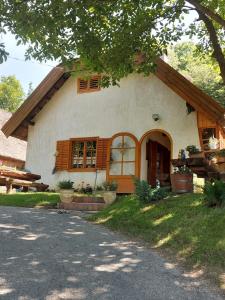 SzőlősgyörökLandhaus mit Weinkeller - Nádas Pince的一间白色的小房子,设有大门