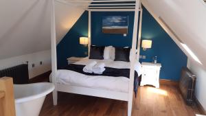 Cerne AbbasThe New Inn的一间卧室配有一张带华盖的床和浴缸