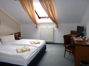 Tautenhain祖尔克奈尼酒店的一间卧室配有一张床和一张带电脑的书桌