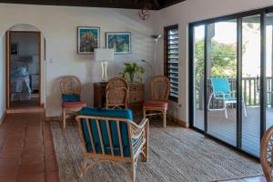 维尔京戈尔达岛VILLA DEL SOLE的客厅配有椅子和带滑动玻璃门的门廊