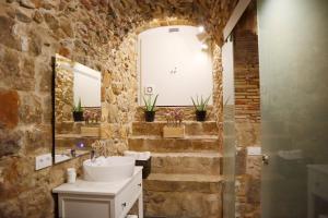 赫罗纳Girona Catedral的一间带水槽和石墙的浴室