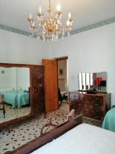 焦约萨马雷阿Casa Vacanze Gioiosa Marea的一间带镜子、床和吊灯的卧室