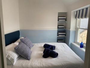 圣艾夫斯Little Dolly sea view 2 bedroom apartment, St Ives town, dog friendly的一张带两个蓝色和白色枕头的床