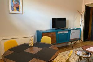 维希Vichy Cocoon Appartements的客厅配有桌子和电视