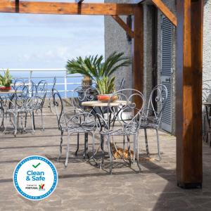 圣若热岛卡萨达斯普罗提斯酒店的露台的桌椅,背景为大海