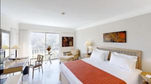 伊瓦格阿尔塔米拉星级酒店的一间卧室配有一张床和一张书桌,另一间卧室配有一张床