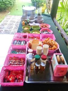 Ban Chieo KoBaan Pak Rim Kuaen Resort的一张桌子,上面放着粉红色的食品和其他食品