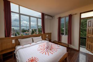 东枝UCT Taunggyi Hotel的一间卧室配有一张红色鲜花的大床