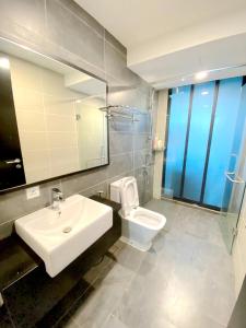 努沙再也Almas Suites Puteri Harbour的一间带水槽、卫生间和镜子的浴室