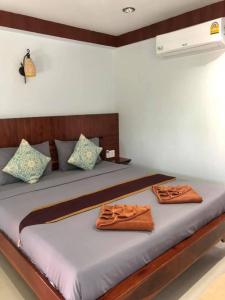 涛岛大海滩度假村的一间卧室配有一张床,上面有两条毛巾