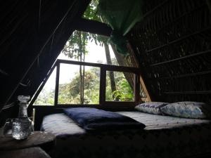 特纳Jungle Roots的窗户客房内的一张床位