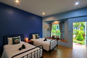 尖竹汶Little Cottage的一间卧室设有两张床和蓝色的墙壁
