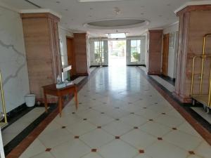杜拉特阿拉尔Durrah Beach Apartment的空的走廊,房间里有桌子