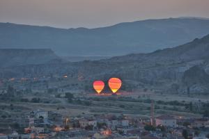 格雷梅Cappadocia Cave Lodge的两只热气球飞越城市