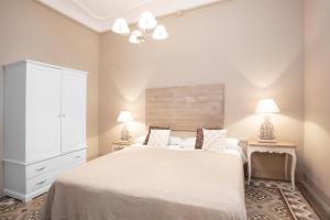 巴塞罗那BCN兰布拉加泰罗尼亚公寓的卧室配有一张白色大床和两盏灯。