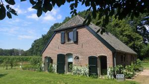 HummeloVakantiehuis Het Wapen van Heeckeren的红砖建筑,设有绿色门窗