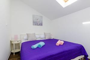 斯顿Holiday Home Barbara的一间卧室配有一张紫色床和两个枕头
