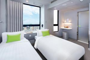 香港旭逸酒店(旺角)的带大窗户的客房内的两张床