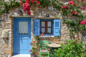 加里尼Naxos Filoxenia Hotel的蓝色门和鲜花的石头房子