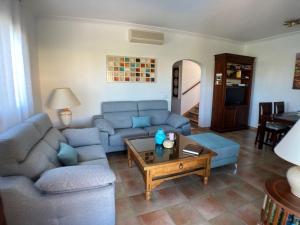 克里斯托港Holiday Home Schnuffi - PCN155 by Interhome的客厅配有蓝色的沙发和咖啡桌