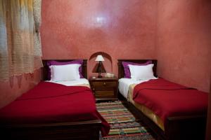 拉巴特里亚德达尔阿里亚酒店的红色墙壁客房的两张床