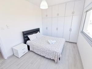 拉纳卡Mackenzie Seaview Paradise的白色卧室配有一张床和白色橱柜