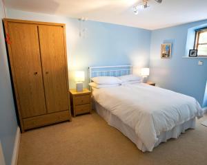 利马瓦迪Ballyhenry House and Apartments的卧室配有白色的床和蓝色的墙壁